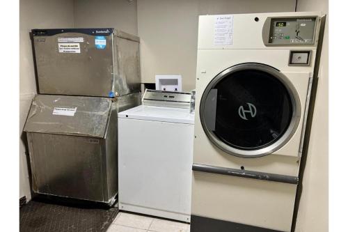a washing machine sitting next to a dryer in a room at Devils Lake Inn By OYO Near Devils Lake Regional Airport in Devils Lake