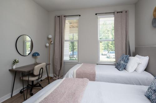 ein Schlafzimmer mit zwei Betten und einem Schreibtisch und einem Spiegel in der Unterkunft Charming, New Apt, Pool, Long Stays in Athens