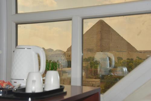 a window with a view of the pyramids at Pyramids Wonders Hotel in Cairo
