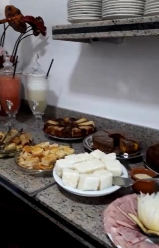 a table topped with plates of cheese and other food at Flor de Limão Hotel Boutique in Coroa Vermelha