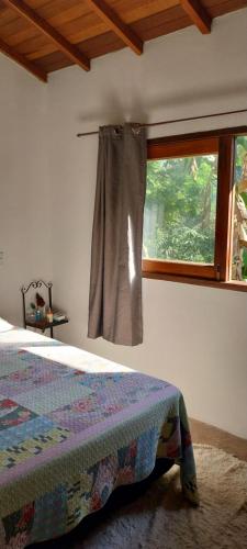 a bedroom with a bed and a window at Casa Ponte Branca em Paraty in Paraty