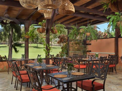 a patio with tables and chairs and plants at Green Garden Eco Resort in Playa de las Americas