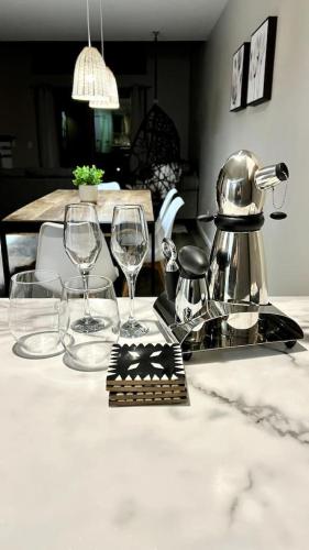 a table with two wine glasses and a tea kettle at Waterfront Boho Retreat in Wisconsin Dells