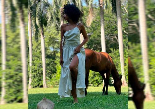 a woman in a dress standing next to a horse at HOTEL SANTAFE NATURA - SANTAFE DE ANTIQUIA in Santa Fe de Antioquia