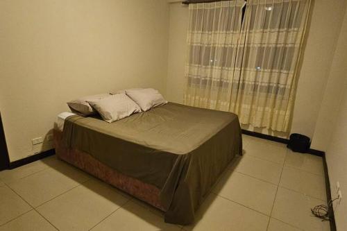 a bed with two pillows on it in a bedroom at Departamento Entero in Vallejos