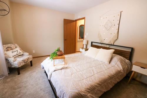 a bedroom with a large bed and a chair at Waterfront Boho Retreat in Wisconsin Dells