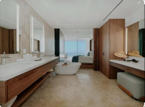 a bathroom with a tub and a sink and a bed at Beachfront, Viceroy, San José del Cabo, 5 star in San José del Cabo