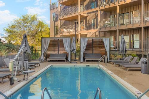 uma piscina com cadeiras e um prédio em Luxury in The Gulch with Patio Pool Walk to Broadway em Nashville