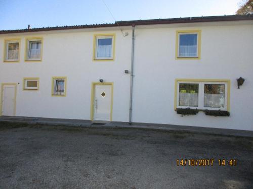 a white house with a yellow door and windows at Gästehaus Erika in Marschall