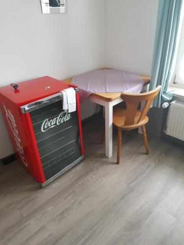 a small room with a table and a cocacola refrigerator at Gästehaus Erika in Marschall