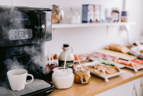 a kitchen counter with a coffee maker and some food at Aska, Modern Cabin in Myvatn