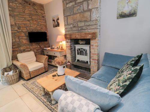 a living room with a blue couch and a fireplace at The Coquet Nest in Morpeth