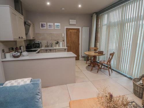 a kitchen and living room with a table and chairs at The Coquet Nest in Morpeth