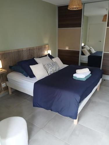 une chambre avec un grand lit et un miroir dans l'établissement Superbe appartement neuf, à Six-Fours-les-Plages