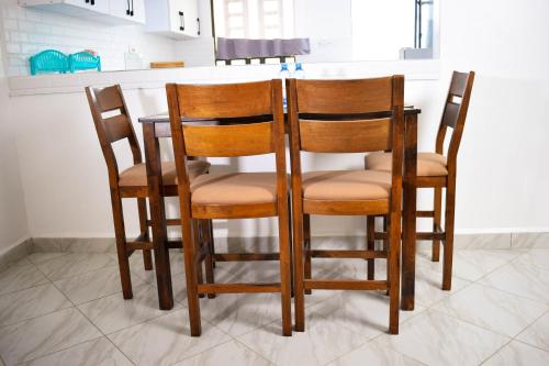 a group of chairs sitting at a kitchen counter at Mzinyi Homes in Voi