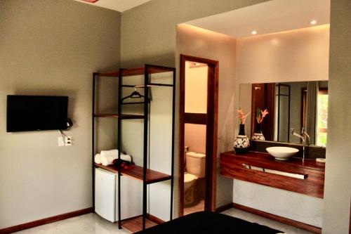 a room with a bathroom with a sink and a mirror at Villa Biju in Jericoacoara