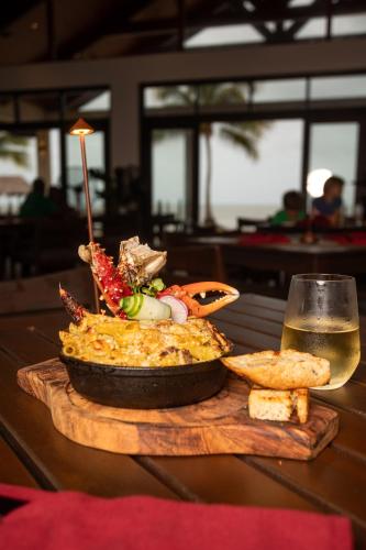 a plate of food on a table with a glass of beer at Seiri del Mar in Hopkins