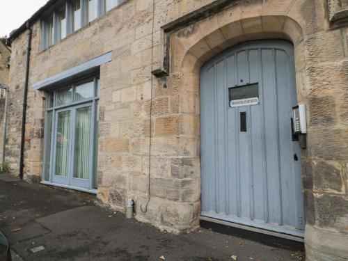 a stone building with a blue door on it at The Coquet Nest in Morpeth