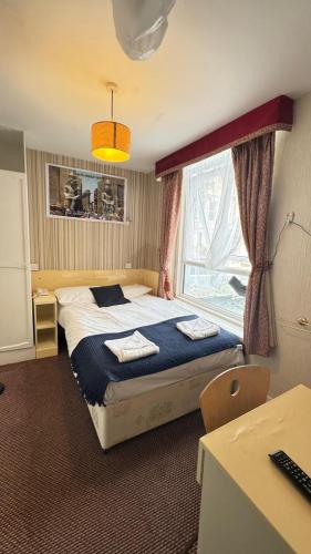 a bedroom with a bed and a window at Earls Court Hotel in London