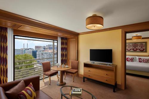 a living room with a television and a large window at Divan Istanbul in Istanbul