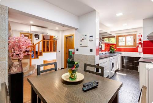 a kitchen and dining room with a wooden table and chairs at Casa da Fonte Gerês in Campo do Gerês