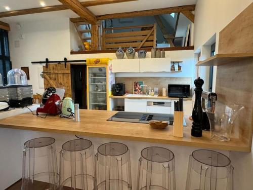 a kitchen with a counter with bar stools at Le Refuge du 55 in Epfig