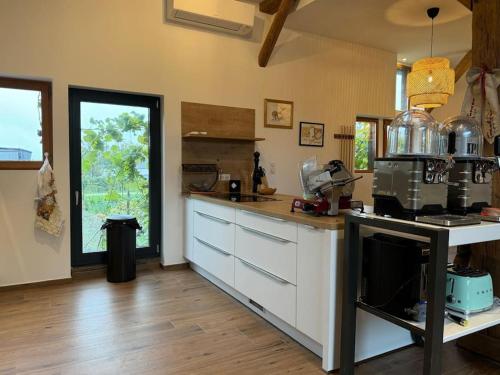 a kitchen with white cabinets and a stove top oven at Le Refuge du 55 in Epfig