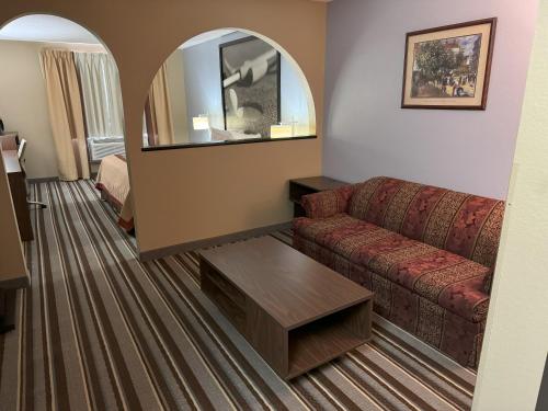 a hotel room with a couch and a mirror at Super 8 by Wyndham Winfield-Quail Ridge Area in Winfield