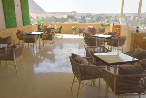 a restaurant with tables and chairs and a large window at Pyramids Wonders Hotel in Cairo