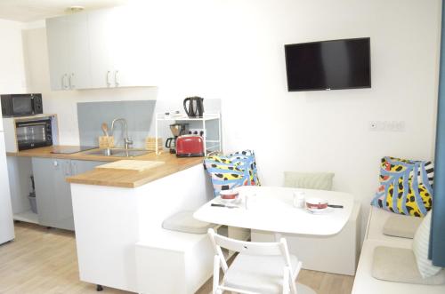a kitchen with a counter and a table and chairs at Amélia in Soulac-sur-Mer
