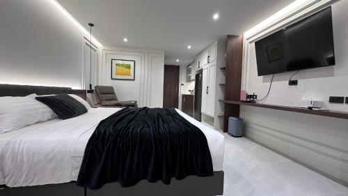 a bedroom with a bed and a flat screen tv at Chill Chill at Nimman in Chiang Mai