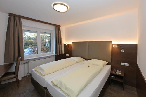 a bedroom with a large bed and a window at Der Kaiserhof Ried in Ried im Innkreis