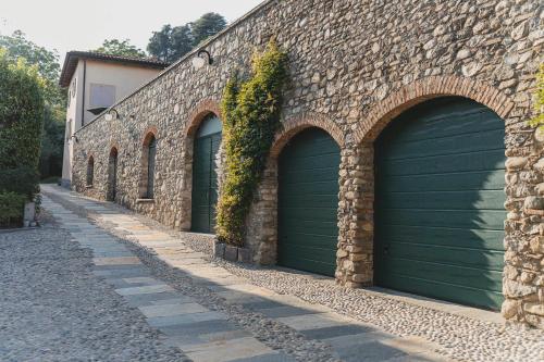 a row of three garage doors on a brick wall at Tenuta Ronco Regio in San Fermo della Battaglia