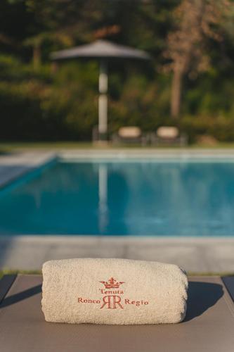 a towel on a table in front of a pool at Tenuta Ronco Regio in San Fermo della Battaglia
