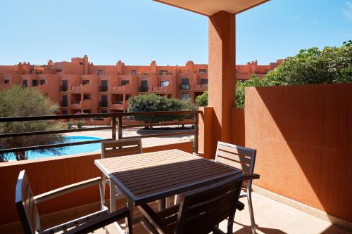 a table and chairs on a balcony with a view of buildings at Garden Suite in Granadilla de Abona