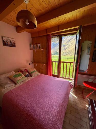 une chambre avec un grand lit avec une grande fenêtre dans l'établissement T2 5 p Champagny-le-Haut, à Champagny-en-Vanoise