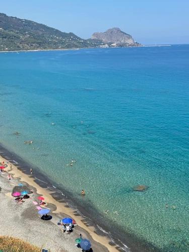 a beach with umbrellas and people in the water at Dimora Rosetta - Appartamento panoramico a pochi minuti dalla spiaggia in SantʼAmbrogio