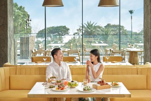 a man and woman sitting at a table in a restaurant at JW Marriott Jeju Resort & Spa in Seogwipo