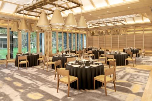 a conference room with tables and chairs and windows at JW Marriott Jeju Resort & Spa in Seogwipo