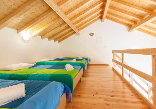 3 camas en una habitación con techo de madera y suelo de madera en Casa de Sao Mamede, en São Mamede