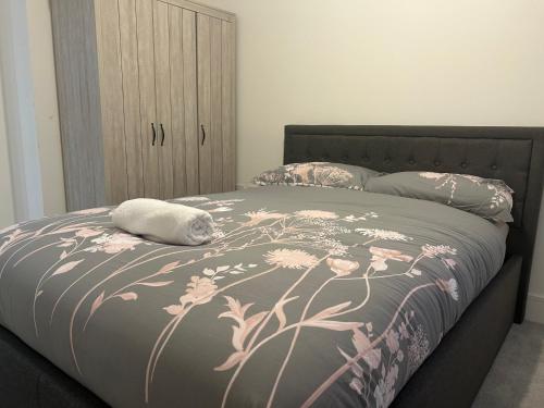 a bedroom with a bed with pink flowers on it at Kinzo's Apartment in Chatham