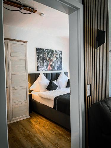 a bedroom with a bed with white sheets and pillows at StayZen Holz & Hirsch Deluxe Hideaway zentral mit Parkplatz in Isny im Allgäu