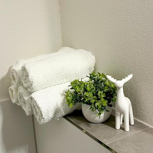 a towel and a plant on a shelf next to a towel at StayZen Holz & Hirsch Deluxe Hideaway zentral mit Parkplatz in Isny im Allgäu
