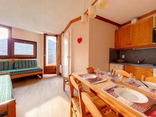 - une cuisine avec une table, des chaises, une table et une table dans l'établissement Appartement cosy 2 pièces - Proche pistes et commerces - Balcon Sud/Est - Parking gratuit - FR-1-344-973, aux Menuires