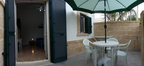a patio with a table and an umbrella at Casa Roberto in Campomarino