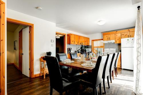 a kitchen with a dining room table and chairs at Le Alesund, 5BR avec SPA, PLAGE et embarcations in Sainte-Lucie-de-Doncaster