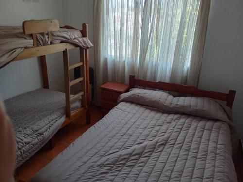 a bedroom with two bunk beds and a window at Departamentos Joaquin in Mar de Ajó