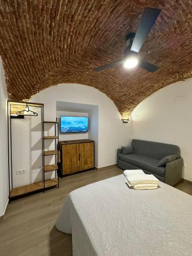 a living room with a bed and a couch at Entre Bóvedas in Cáceres