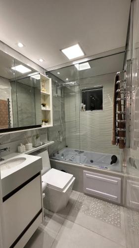 a bathroom with a toilet and a sink and a tub at O melhor Apê da Região com Ar Cond, Wi-Fi e Hidromassagem in Brasilia