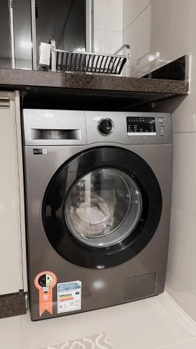a stainless steel washer and dryer in a kitchen at O melhor Apê da Região com Ar Cond, Wi-Fi e Hidromassagem in Brasilia